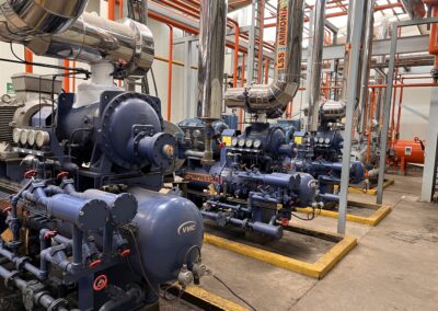 Industrial compressors and pipes in a facility.