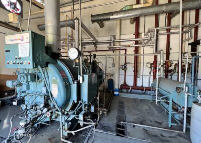 Industrial boiler room with machinery and pipes.